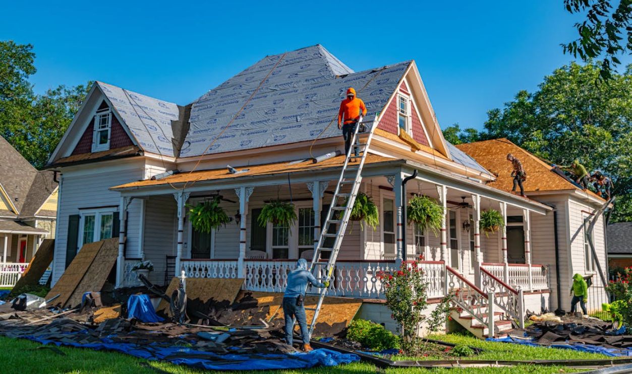 Roofers replace the roof of a historic home in Weatherford, Texas