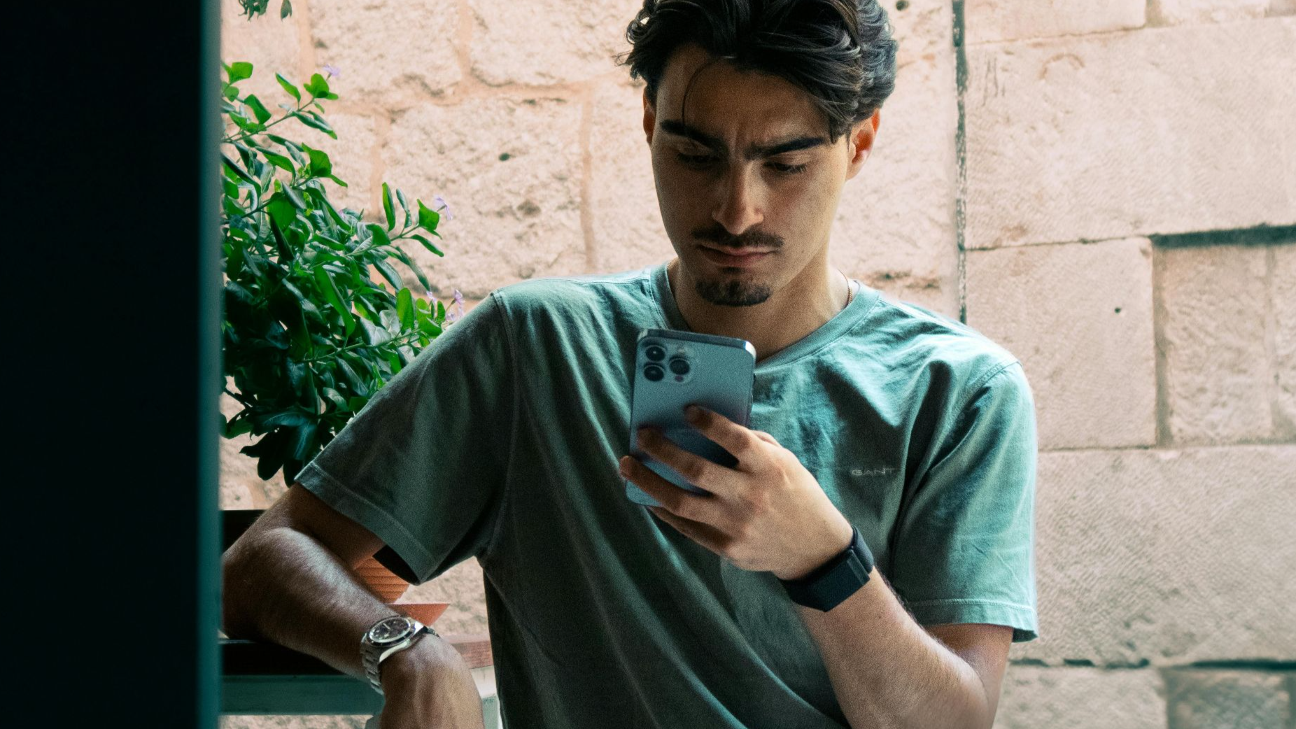 A young man in casual attire checking his phone outside in Split, Croatia