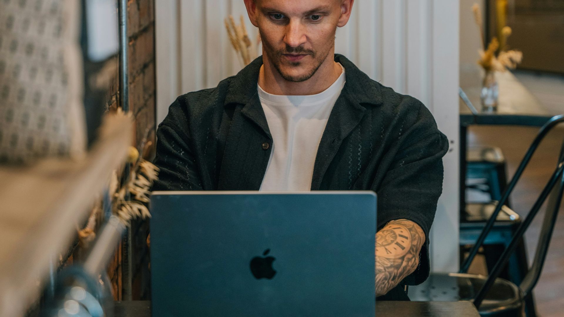A man sitting at a table using a laptop computer