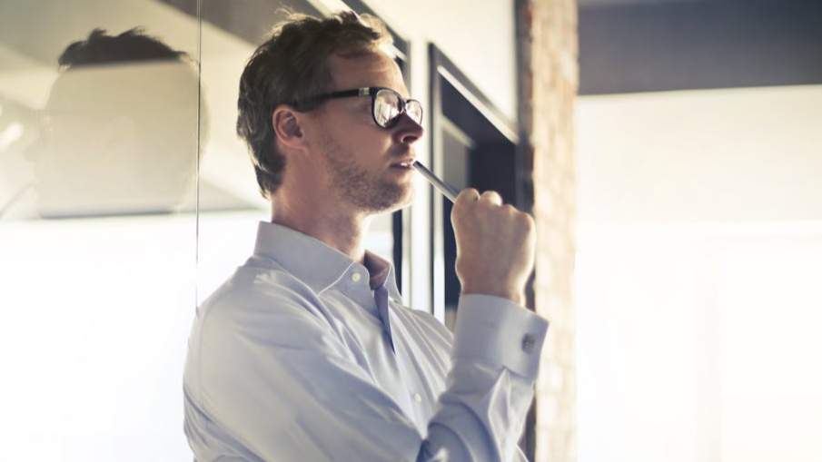 Man thinking in front of a office.