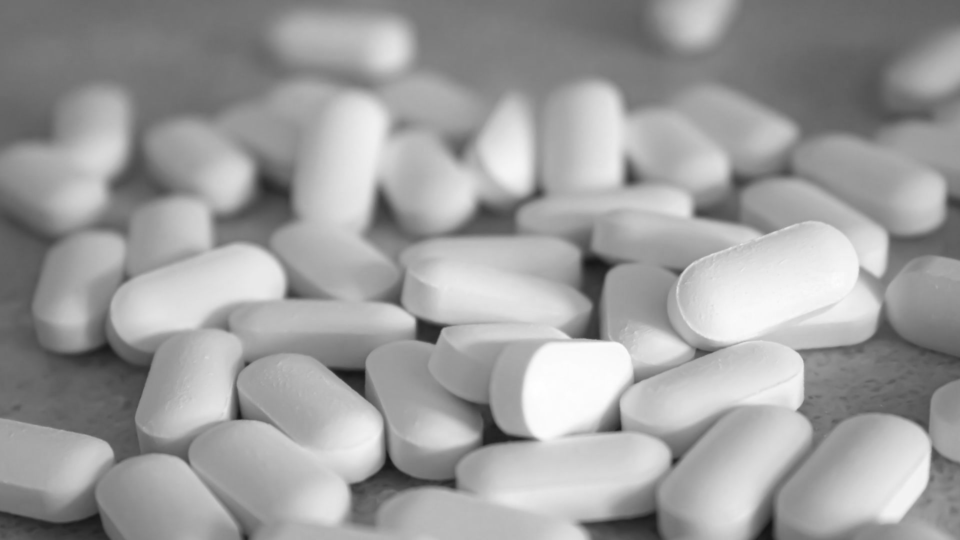 white medication pills on brown surface