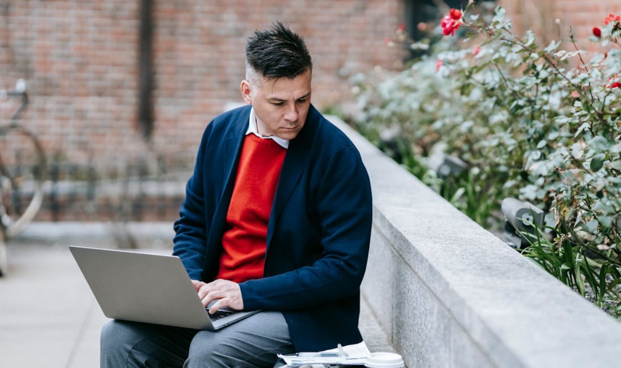 Businessman working remotely on a laptop in an outdoor setting