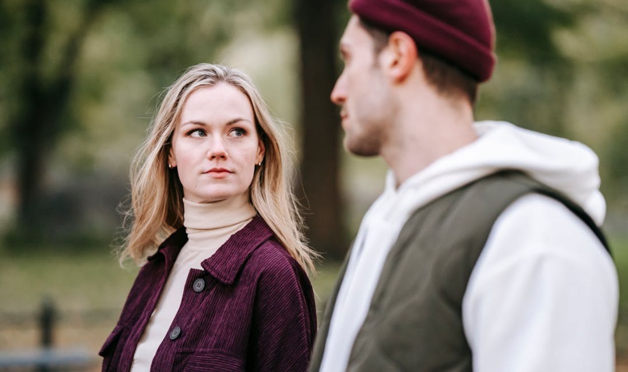 A young couple enjoying a quiet walk in the park during autumn, showcasing their tranquil relationship