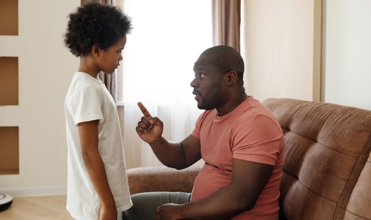 Father and son engaged in a heartfelt conversation on the sofa, illustrating parenting in a loving family setting.