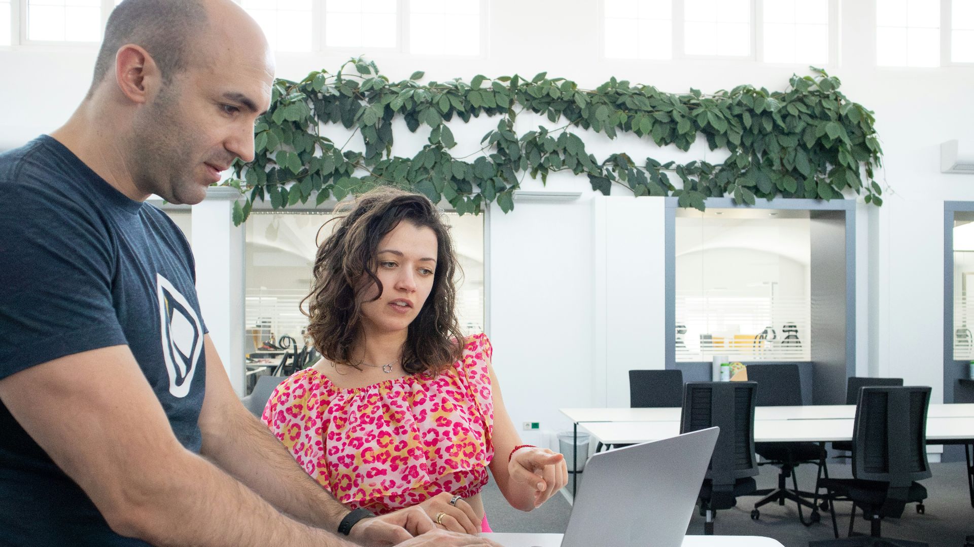 a man and a woman looking at a laptop