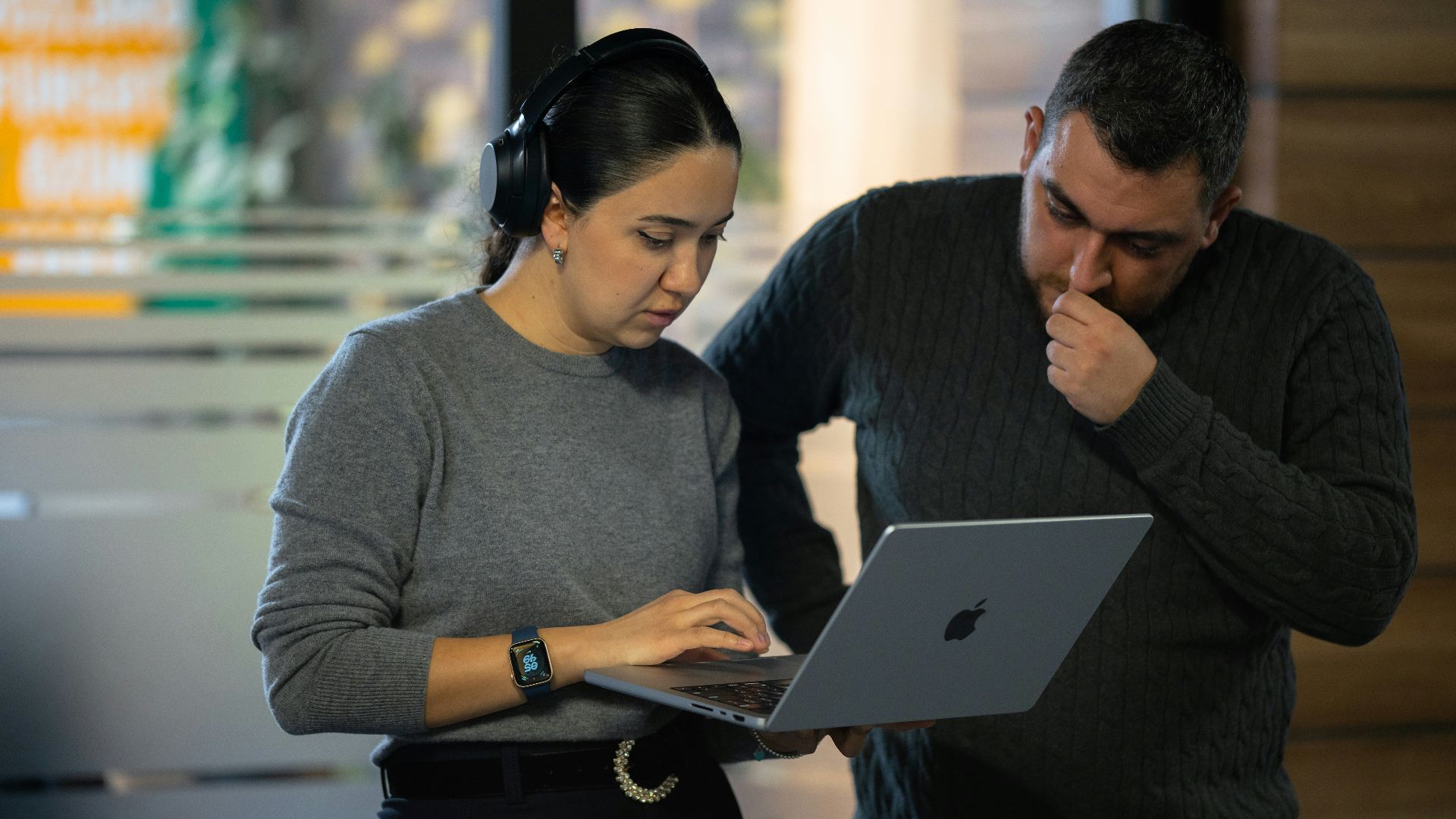 A man and a woman looking at a laptop