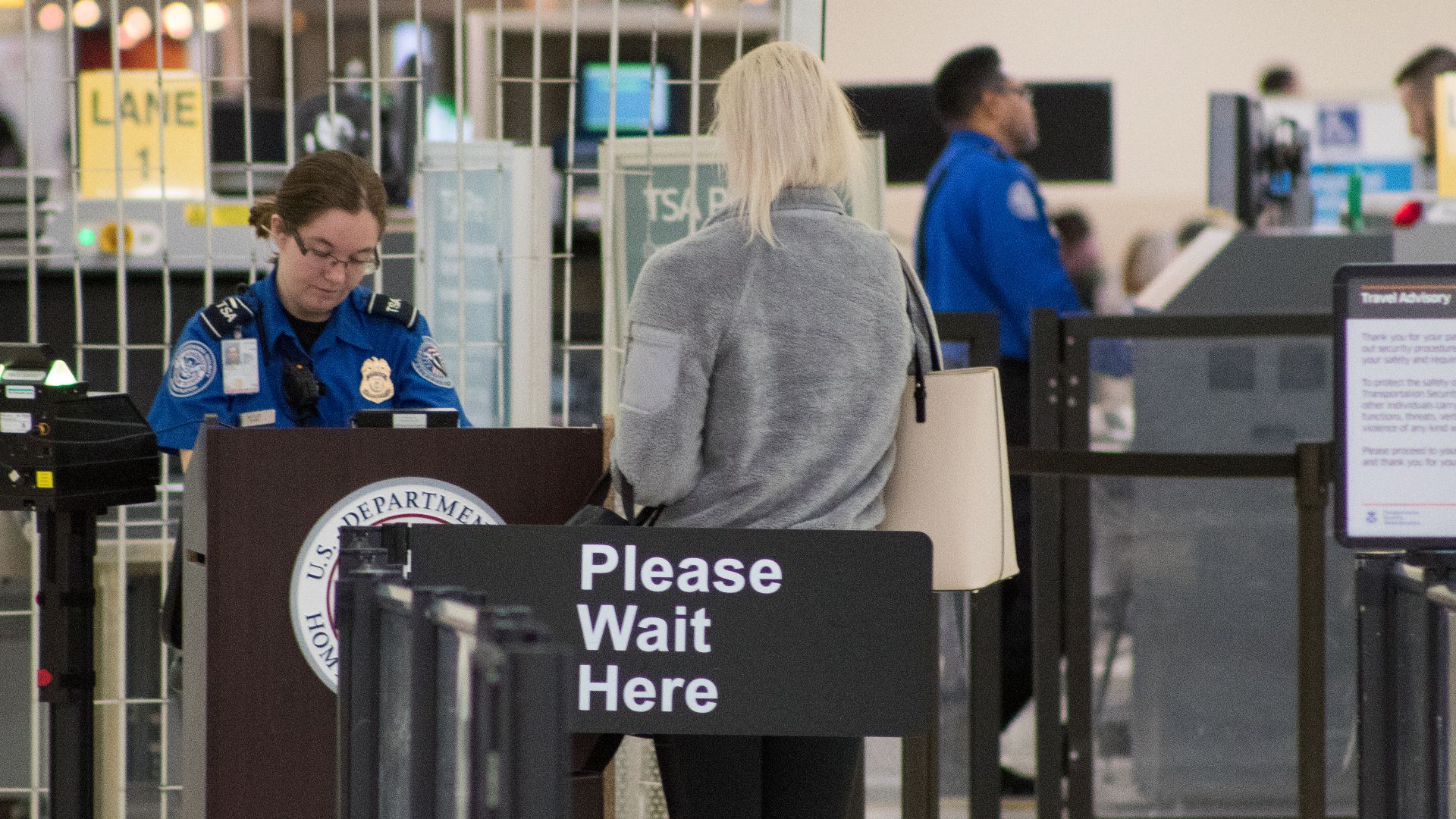 A Transportation Security Administration agent at a checkpoint verifying passenger identification, John Glenn Columbus International Airport