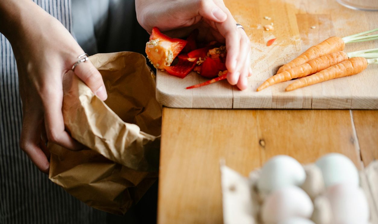 Hands preparing fresh carrots and peppers with eggs on table