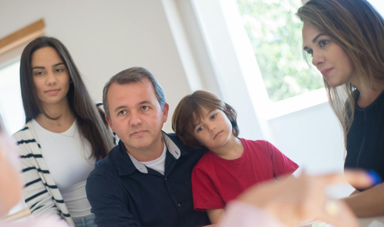 A family of four seeks advice from a professional during an indoor consultation
