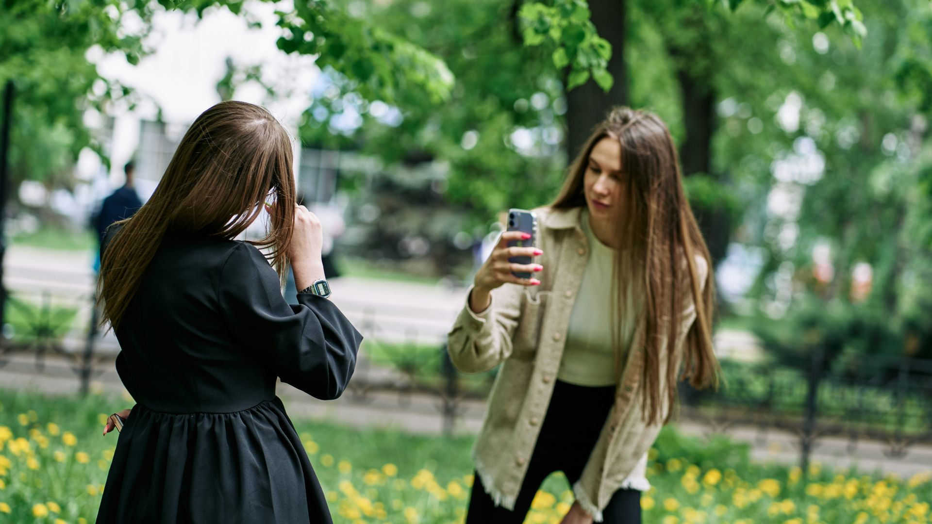 a woman taking a picture of another woman with her cell phone
