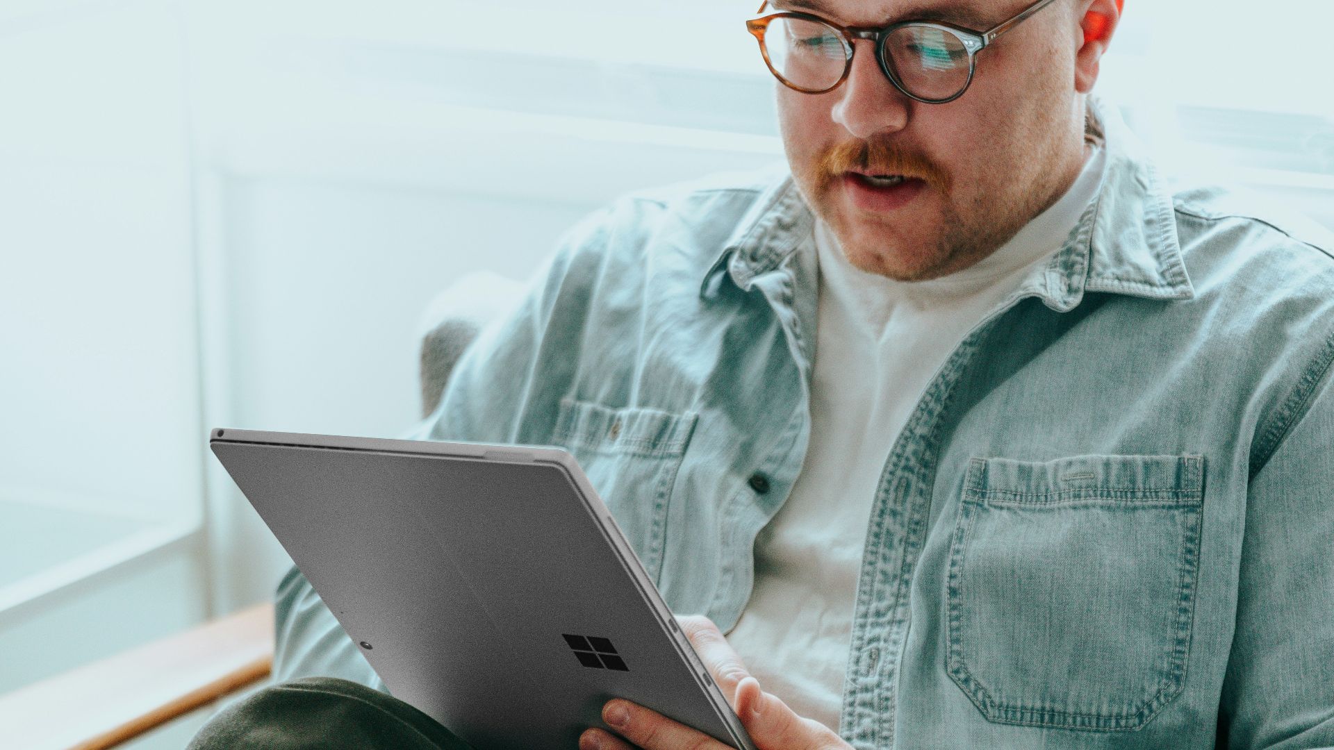 a man sitting on a couch using a laptop computer