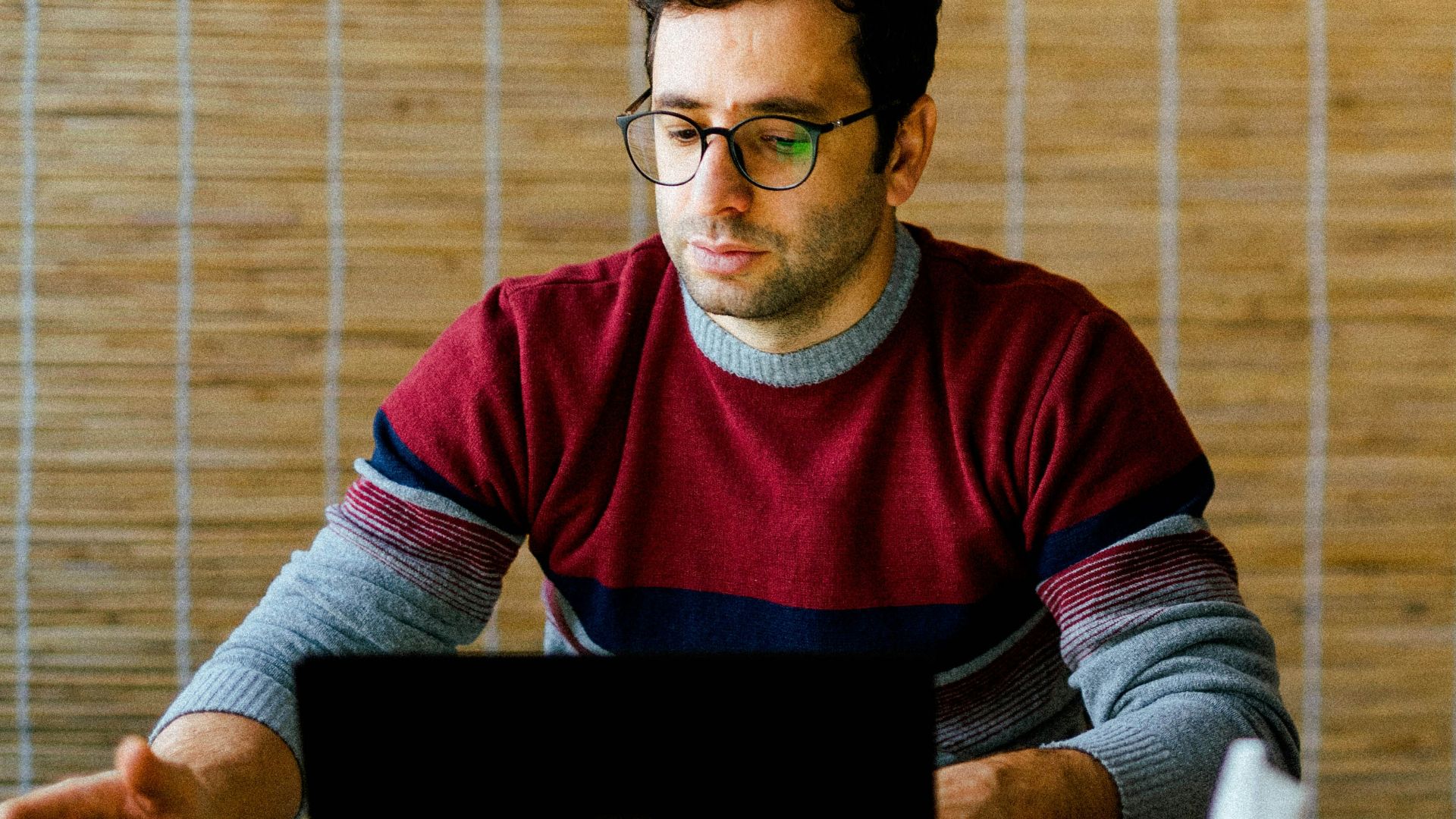a man sitting in front of a laptop computer