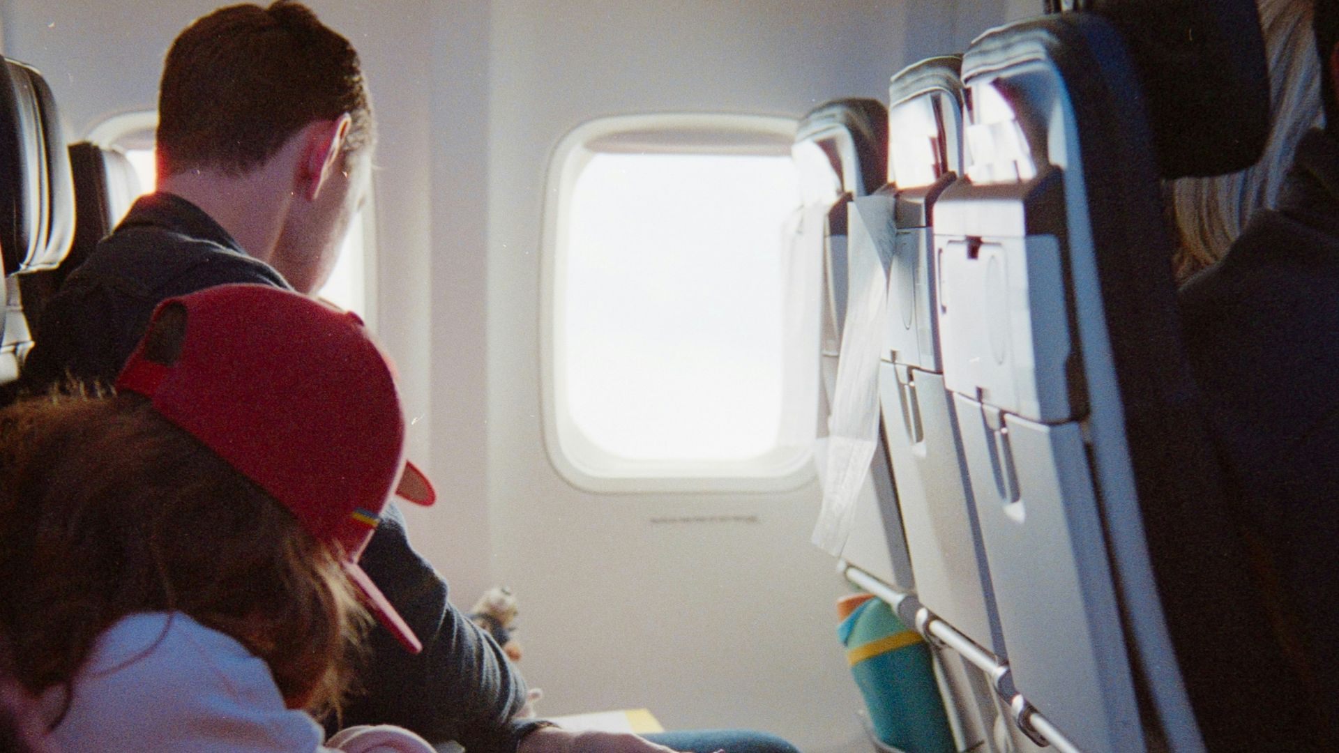 Passengers seated inside an airplane cabin during flight.