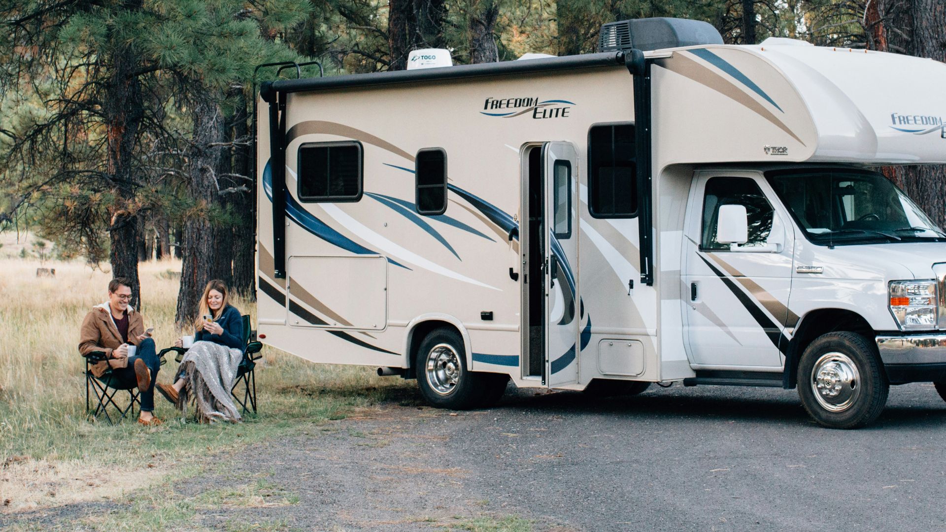 people standing near white rv trailer during daytime