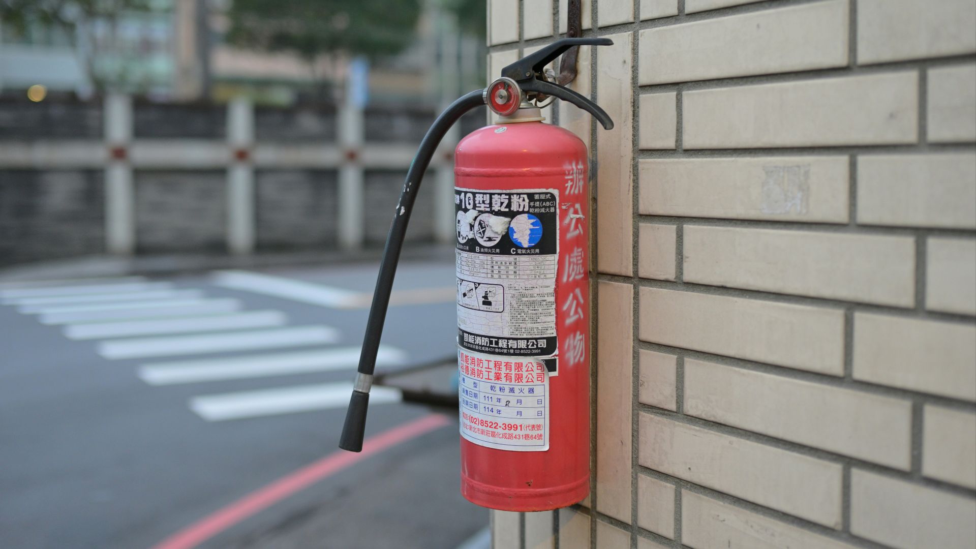 Red fire extinguisher mounted on a brick wall.
