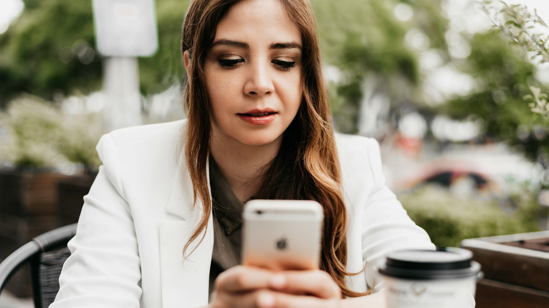 woman in white blazer holding white samsung android smartphone