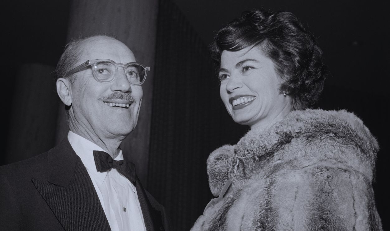 Gettyimages - 2200585505, Mr. & Mrs. Groucho Marx American actor, comedian and singer Groucho Marx, wearing a tuxedo and bow tie, and his wife, American actress Eden Hartford, who wears a fur wrap, attend an event, United States, circa 1960. 