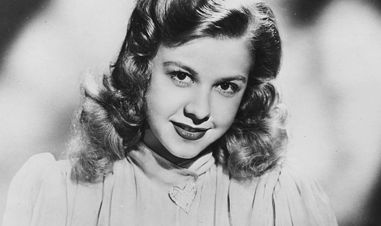 Portrait of actress and dancer Vera-Ellen, wearing a ruffled chiffon dress and a heart shaped brooch, circa 1940. 