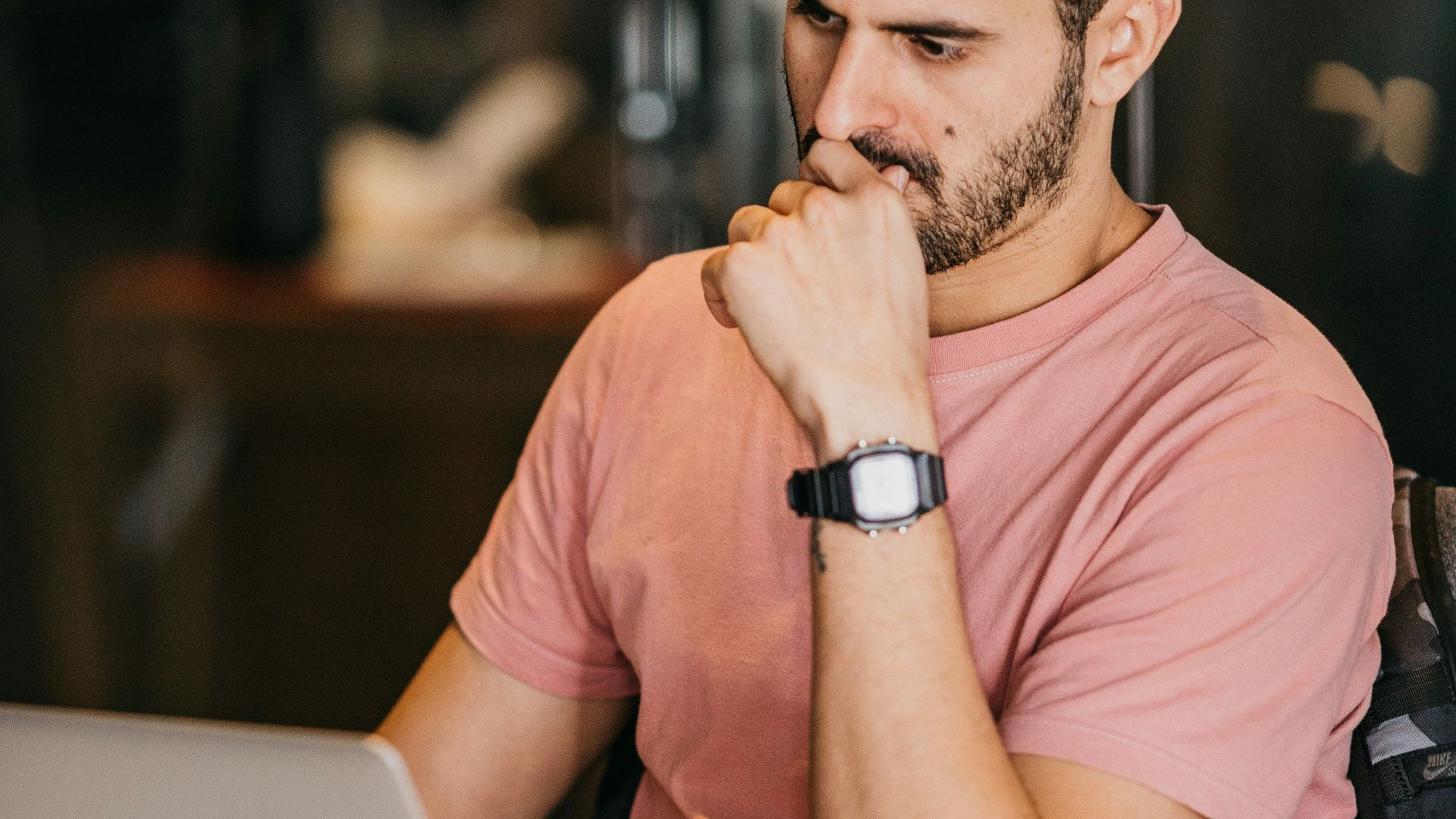 a man sitting at a table with a laptop and a cup