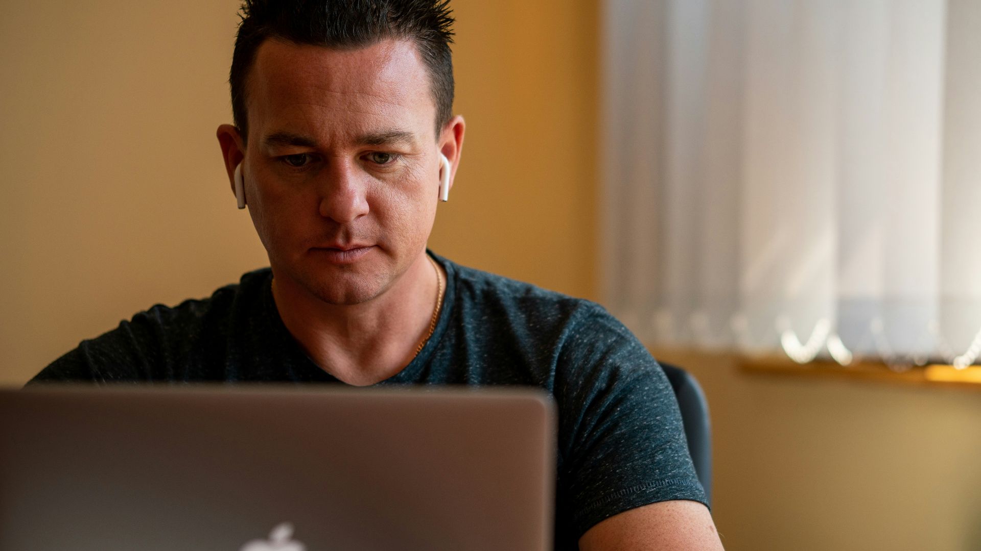 man in blue crew neck t-shirt using silver macbook