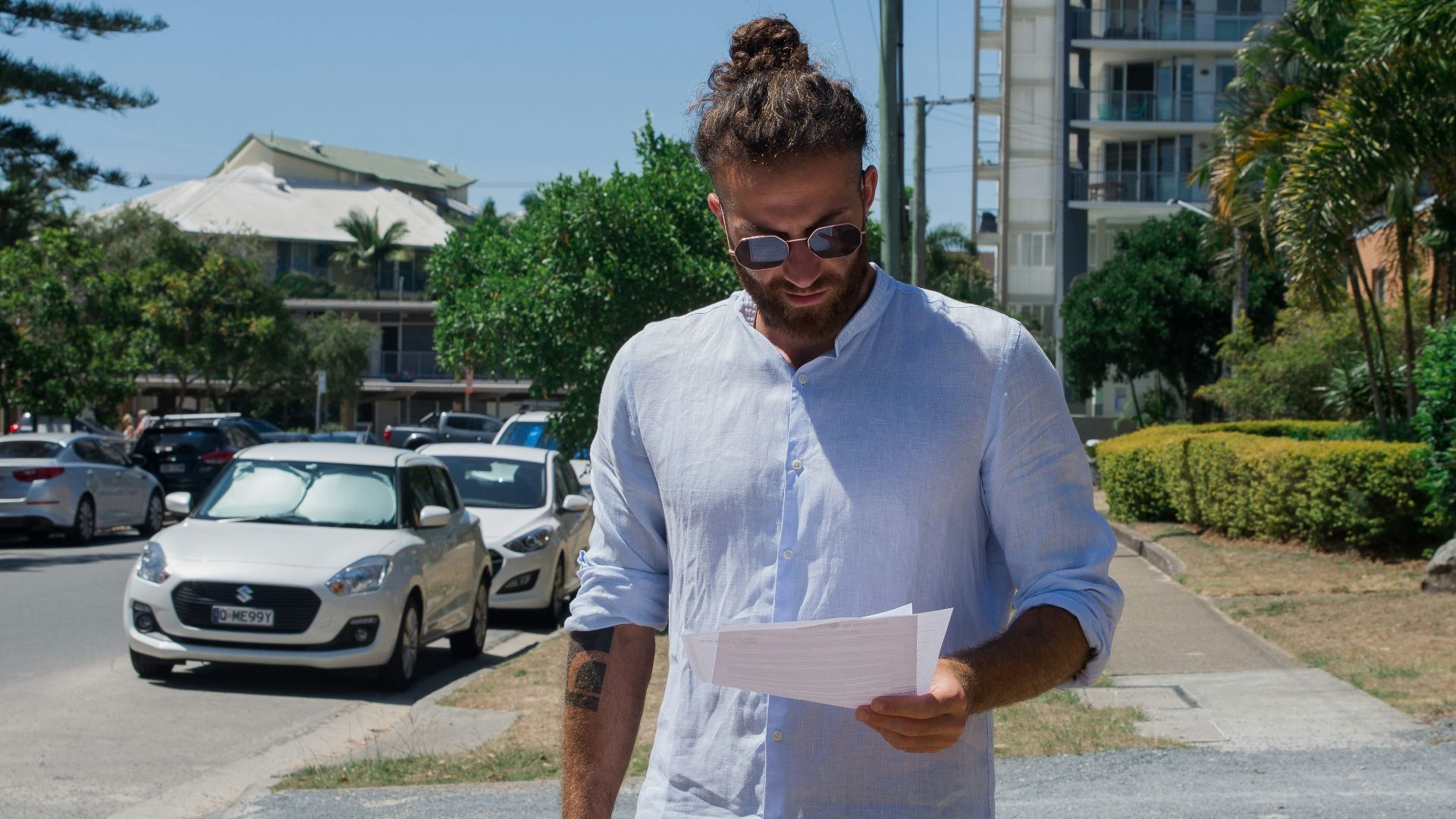 man in white button up t-shirt holding white printer paper