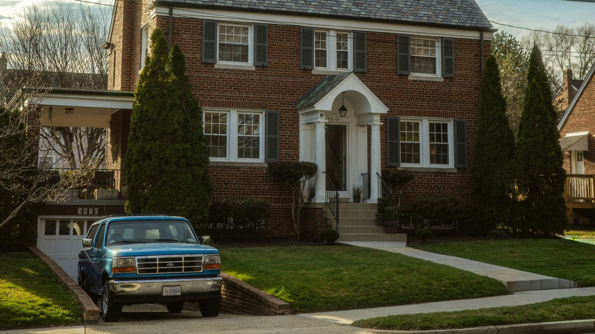 Brick house with a blue truck in the driveway.