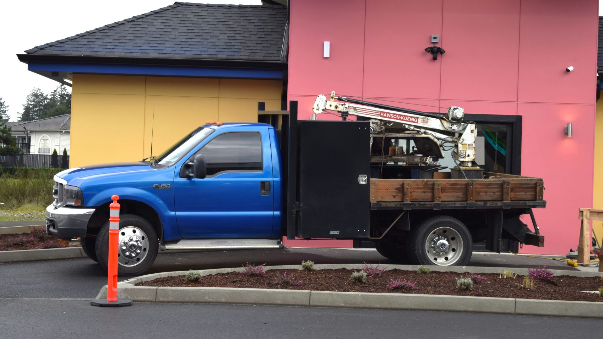 a blue truck parked in front of a pink building