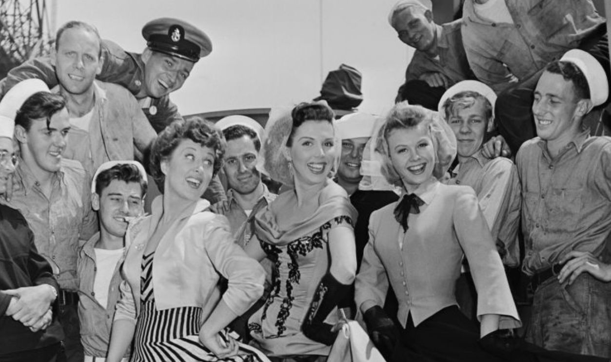 From left to right, actresses Betty Garrett, Ann Miller and Vera-Ellen pose with a group of men during the filming of the movie 'On The Town' in New York City, USA, circa 1949. 