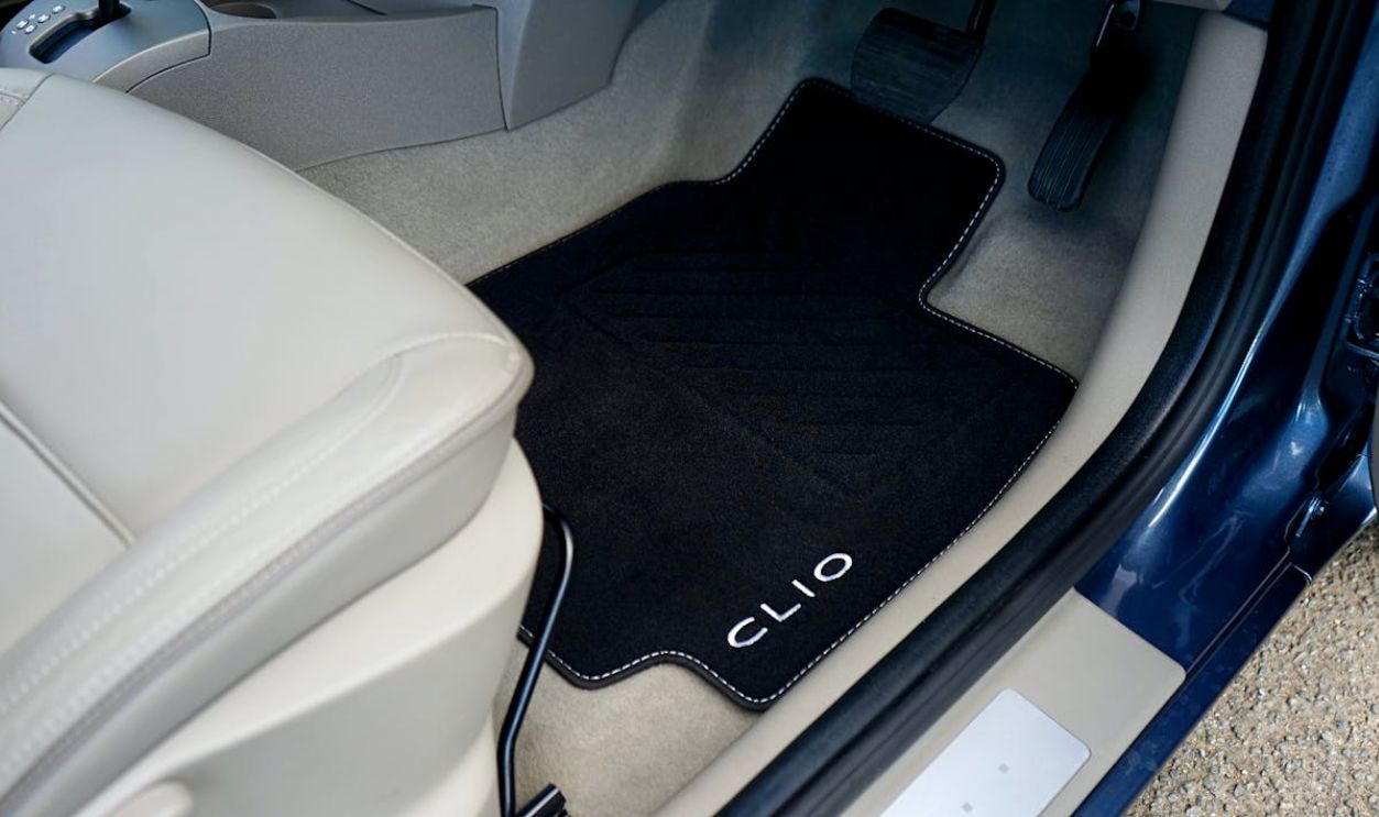 Close-up of Renault Clio car interior showcasing a customized floor mat with branding