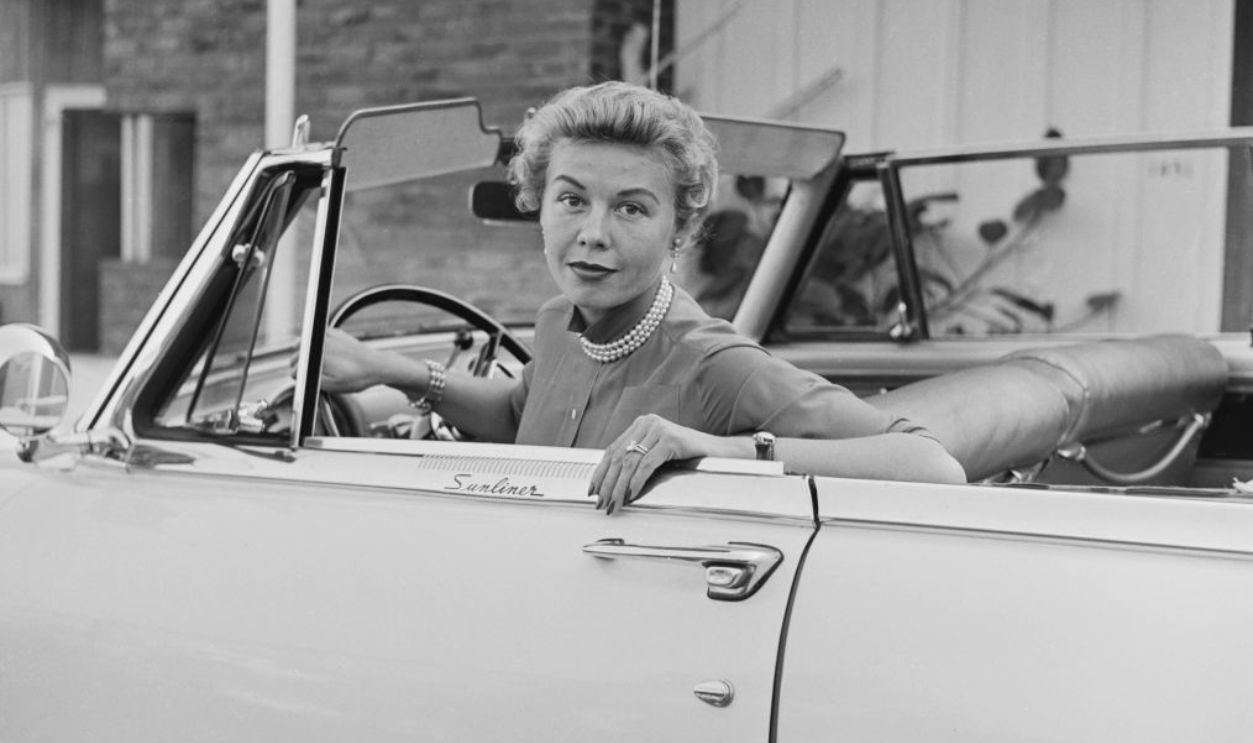 American singer. dancer and actress Vera-Ellen (1921-1981), wearing a pearl necklace, sitting at the wheel of a Ford Fairlane Sunliner, United States, circa 1965. 
