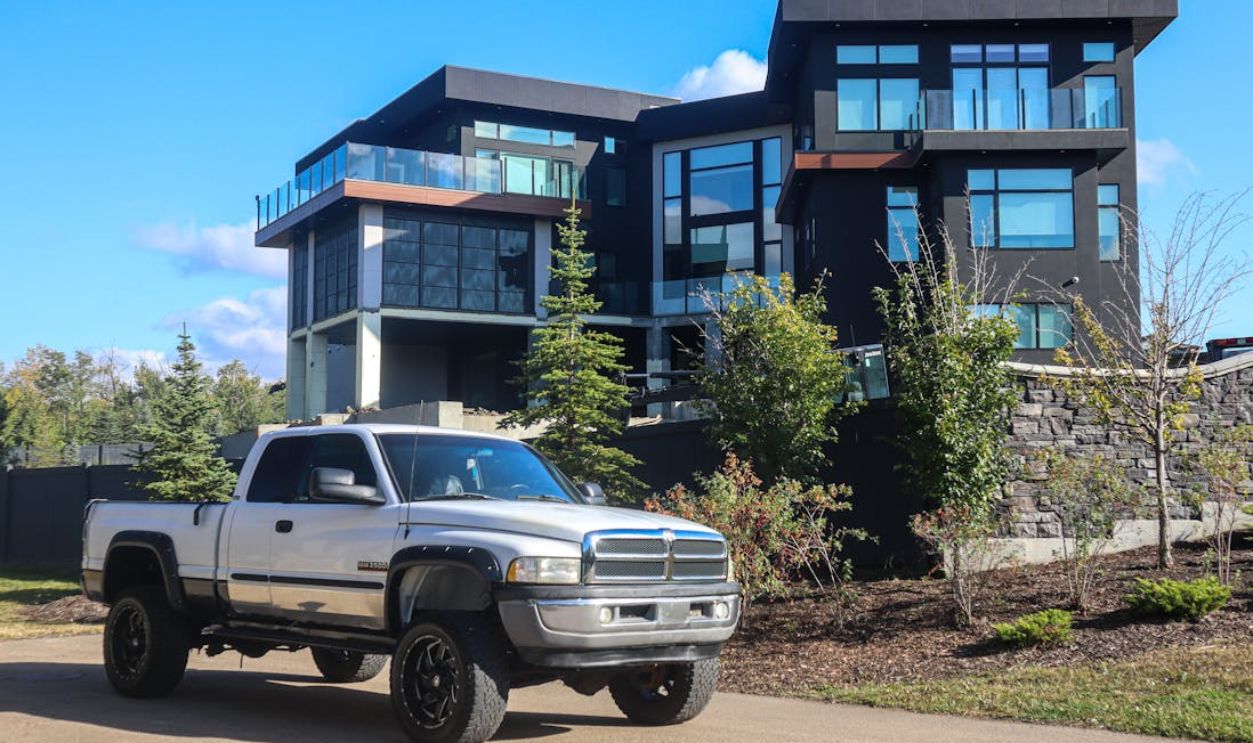 Stylish modern home with a parked silver pickup truck outdoors under a clear blue sky.