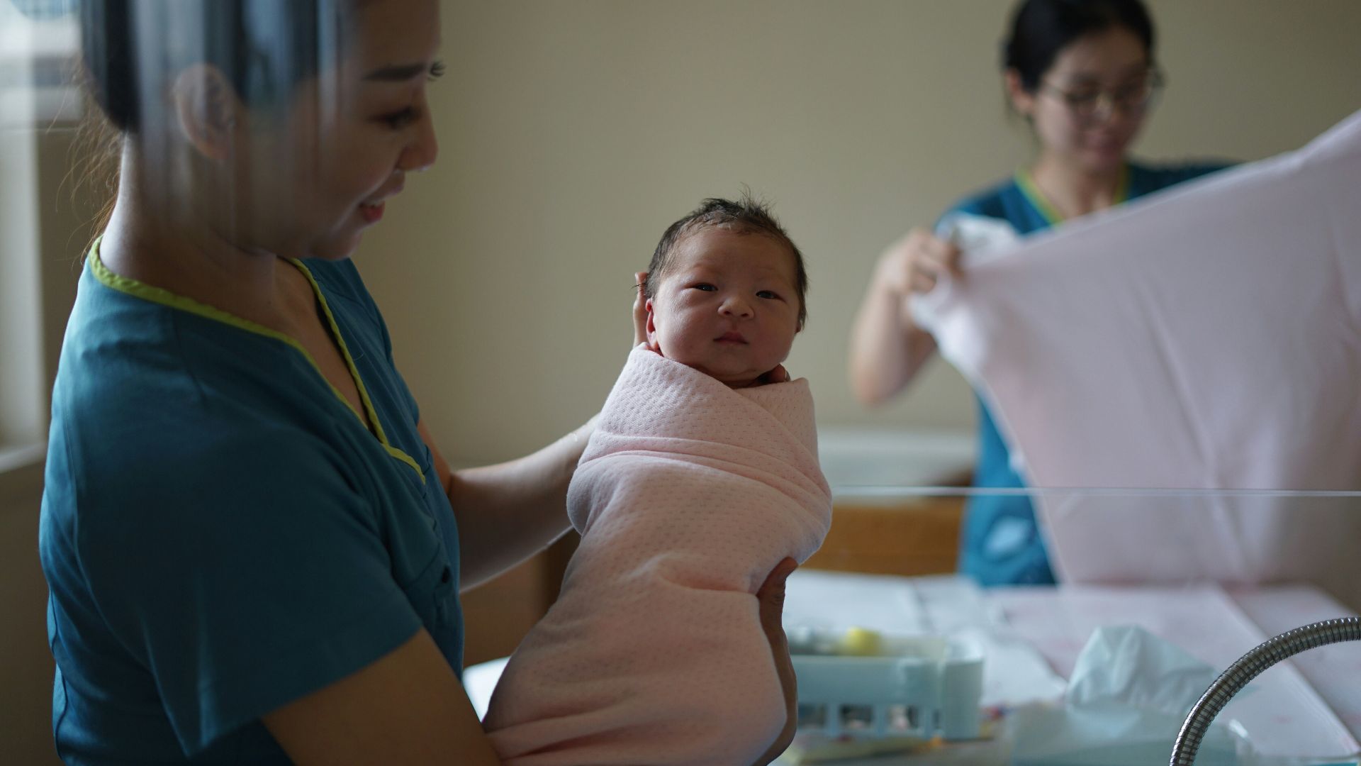 woman carrying newborn baby