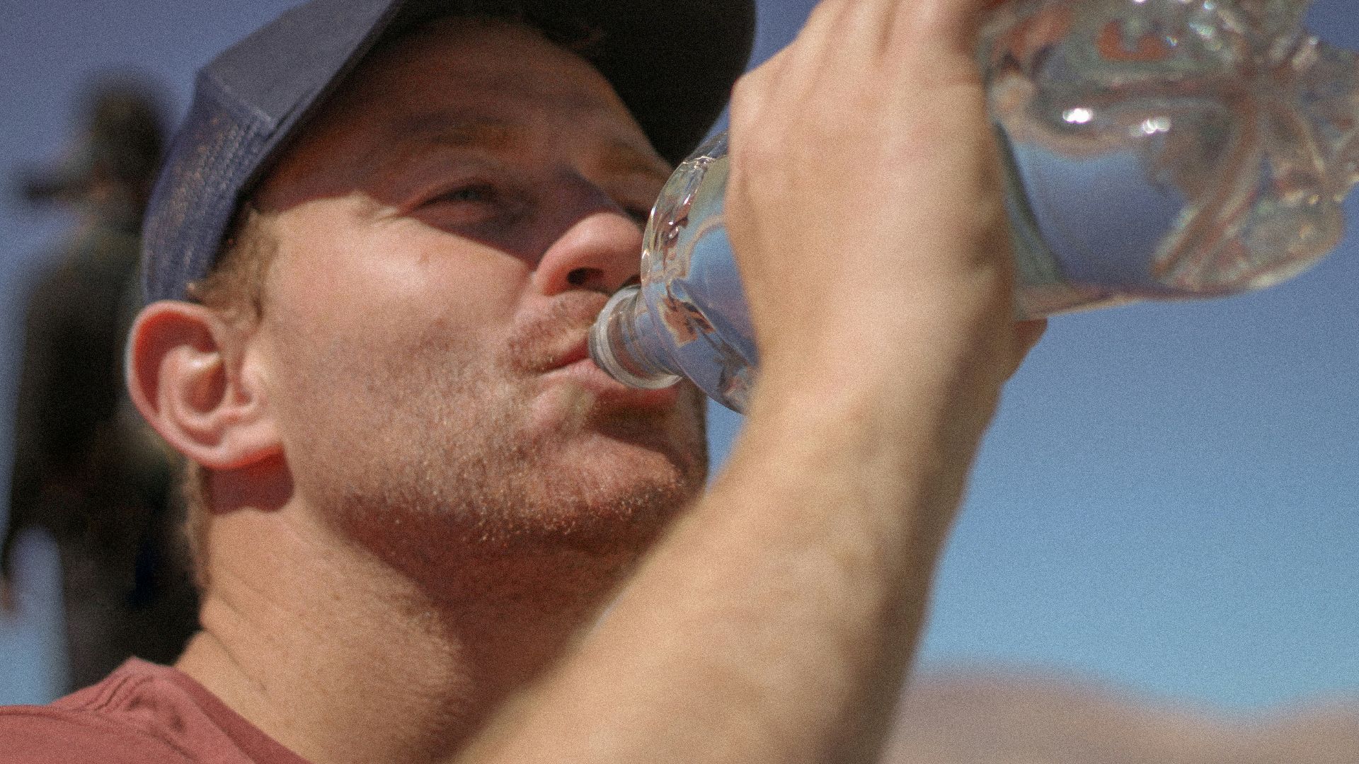 a man drinking water out of a bottle