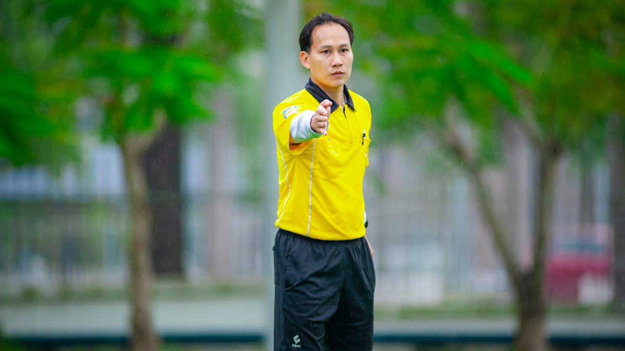 Man in Referee Outfit in Action During Soccer Match