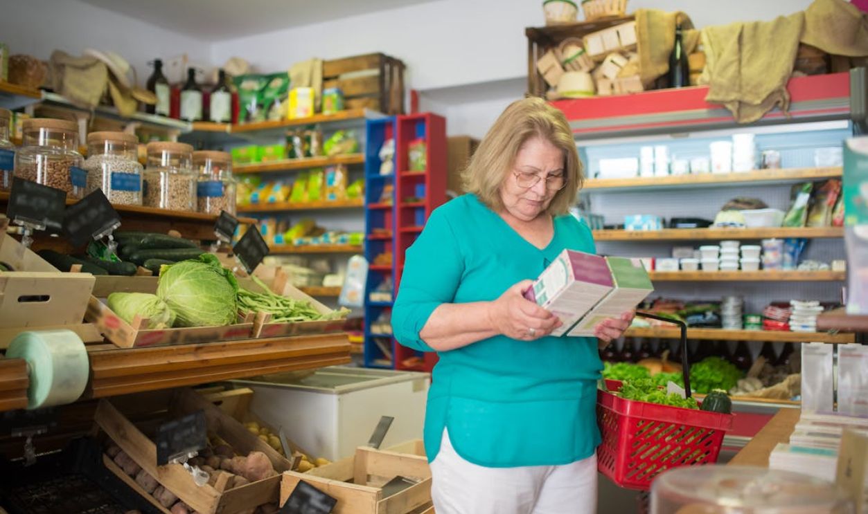 An elderly woman examines a product in a grocery store in Portugal