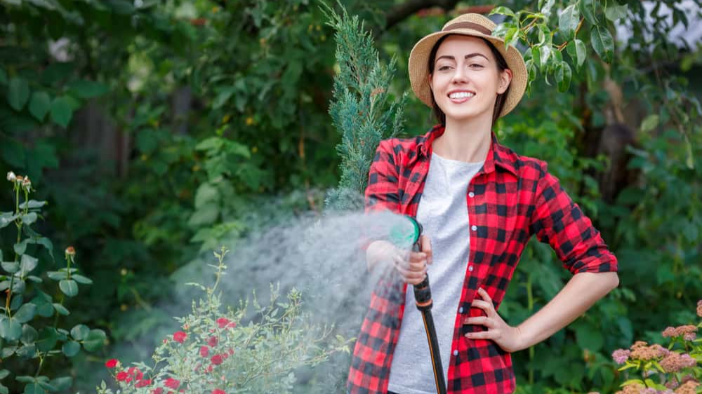 woman hosing backyard