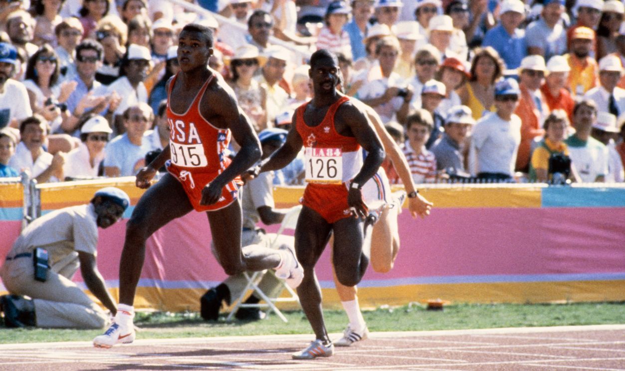 Gettyimages - 1667654665, OLY-1984-LOS ANGELES-ATHLETICS-100M USA's Carl Lewis (L) and Canada's Ben Johnson (R) run the men's 100m heats during the Los Angeles 1984 Summer Olympic Games at the Los Angeles Memorial Coliseum in Los Angeles on August 4, 1984. Carl Lewis won gold and Ben Johnson took bronze. 
