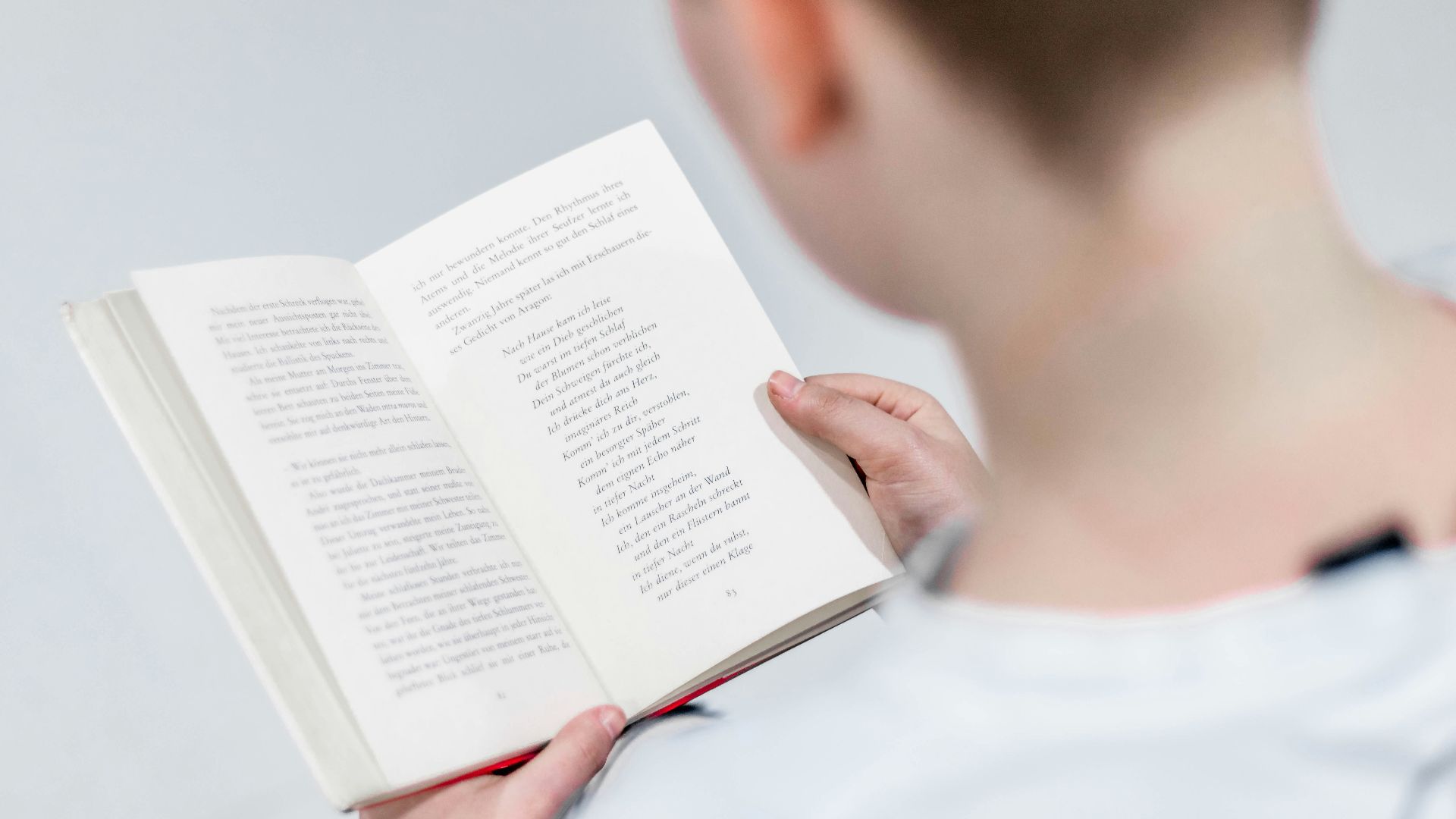 person in white holding book reading