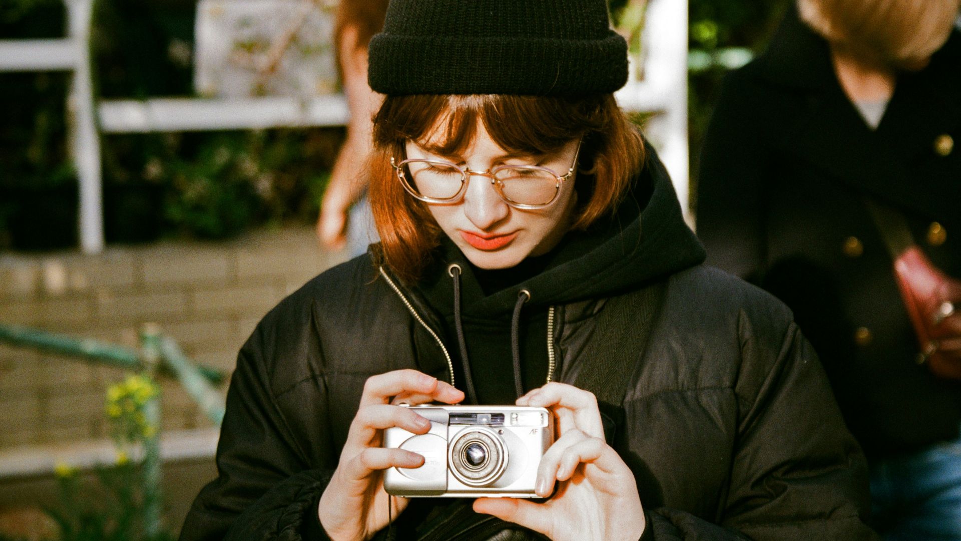 woman in black knit cap holding camera
