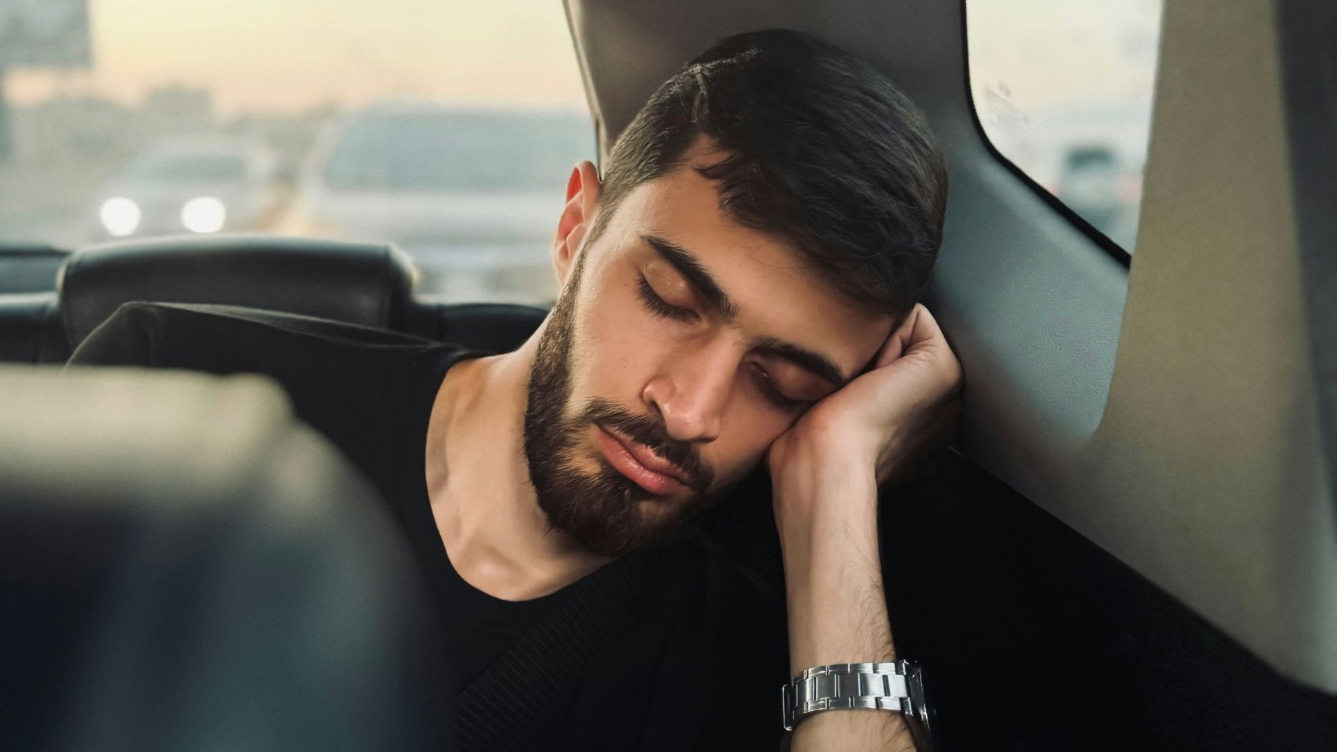 A man sitting in the back seat of a car