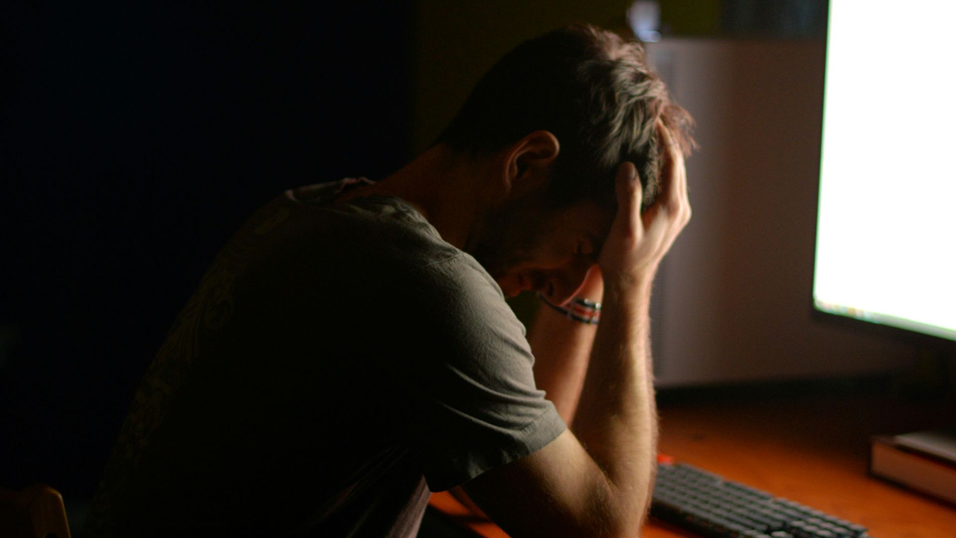 a man sitting at a desk in front of a computer