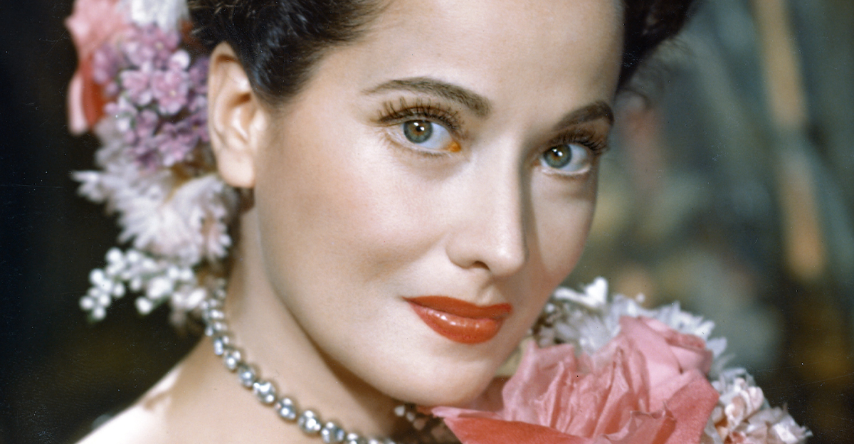 Merle Oberon poses with a bouquet of flowers in 1940.