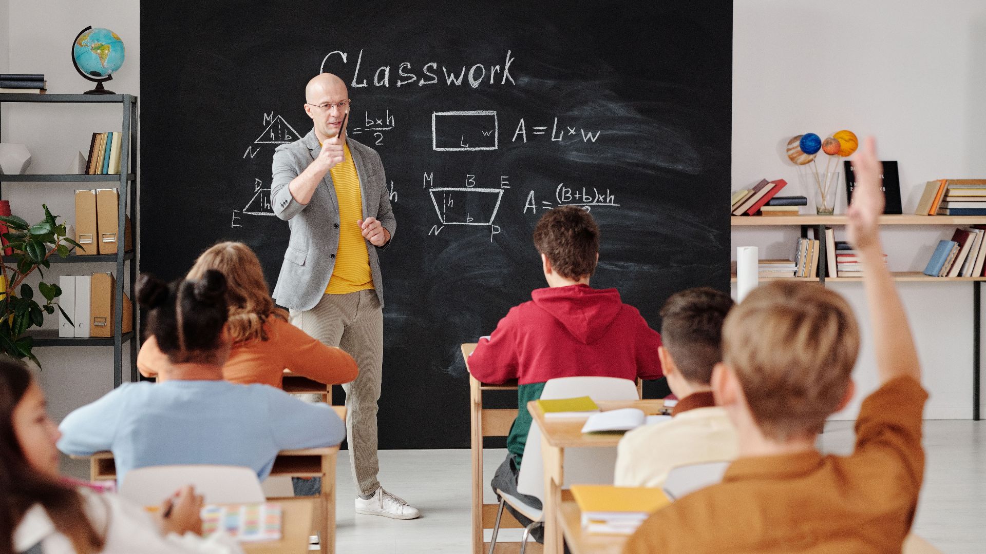 Teacher explaining geometry as students engage in a modern classroom setting.