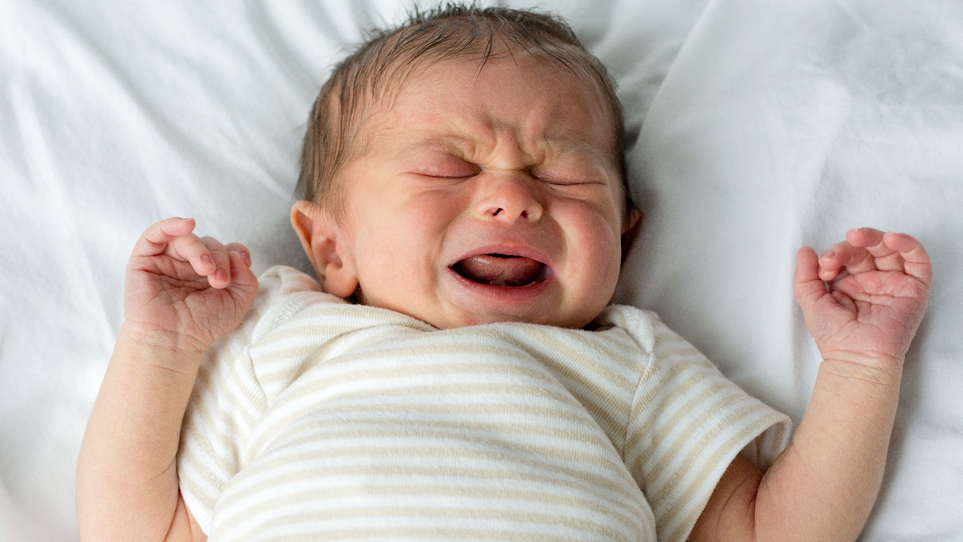 A human male baby, crying.  The baby is only a few days old and still adjusting to life outside of the womb.