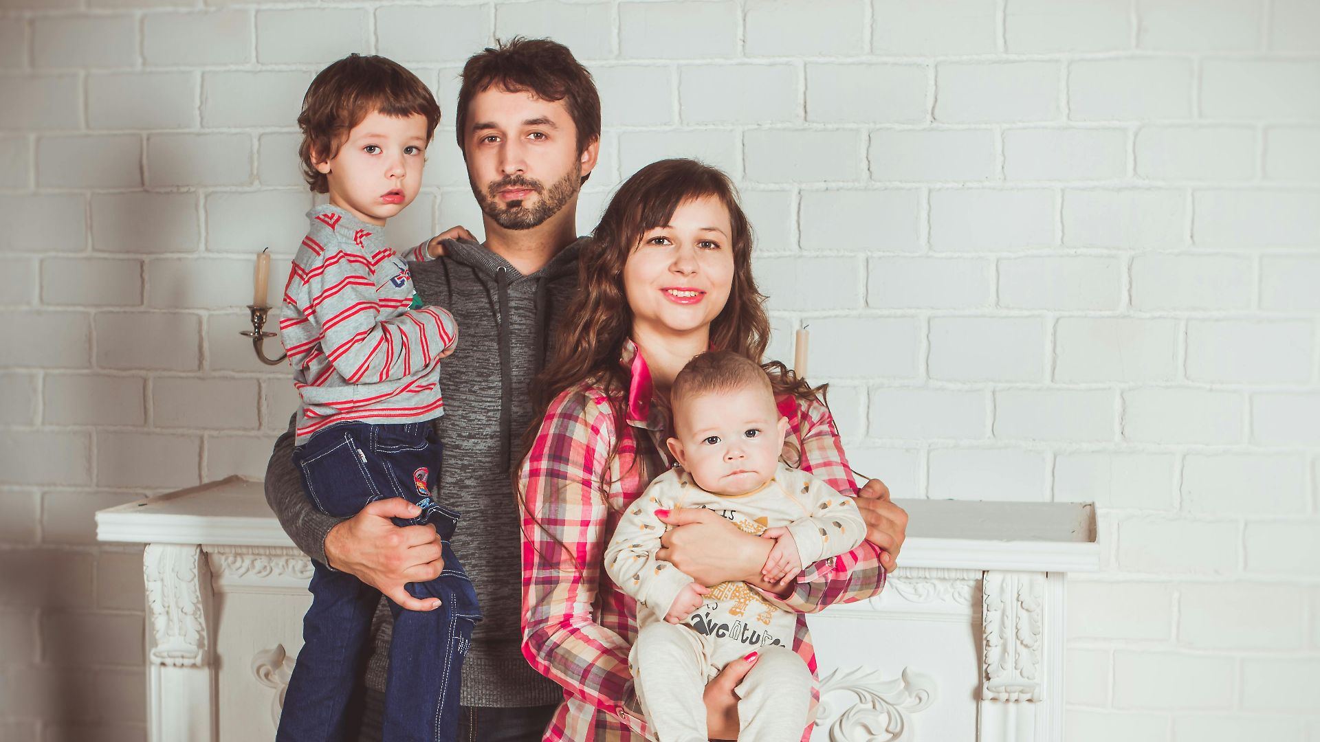 A joyful family posing together in a cozy living room, embodying love and togetherness.