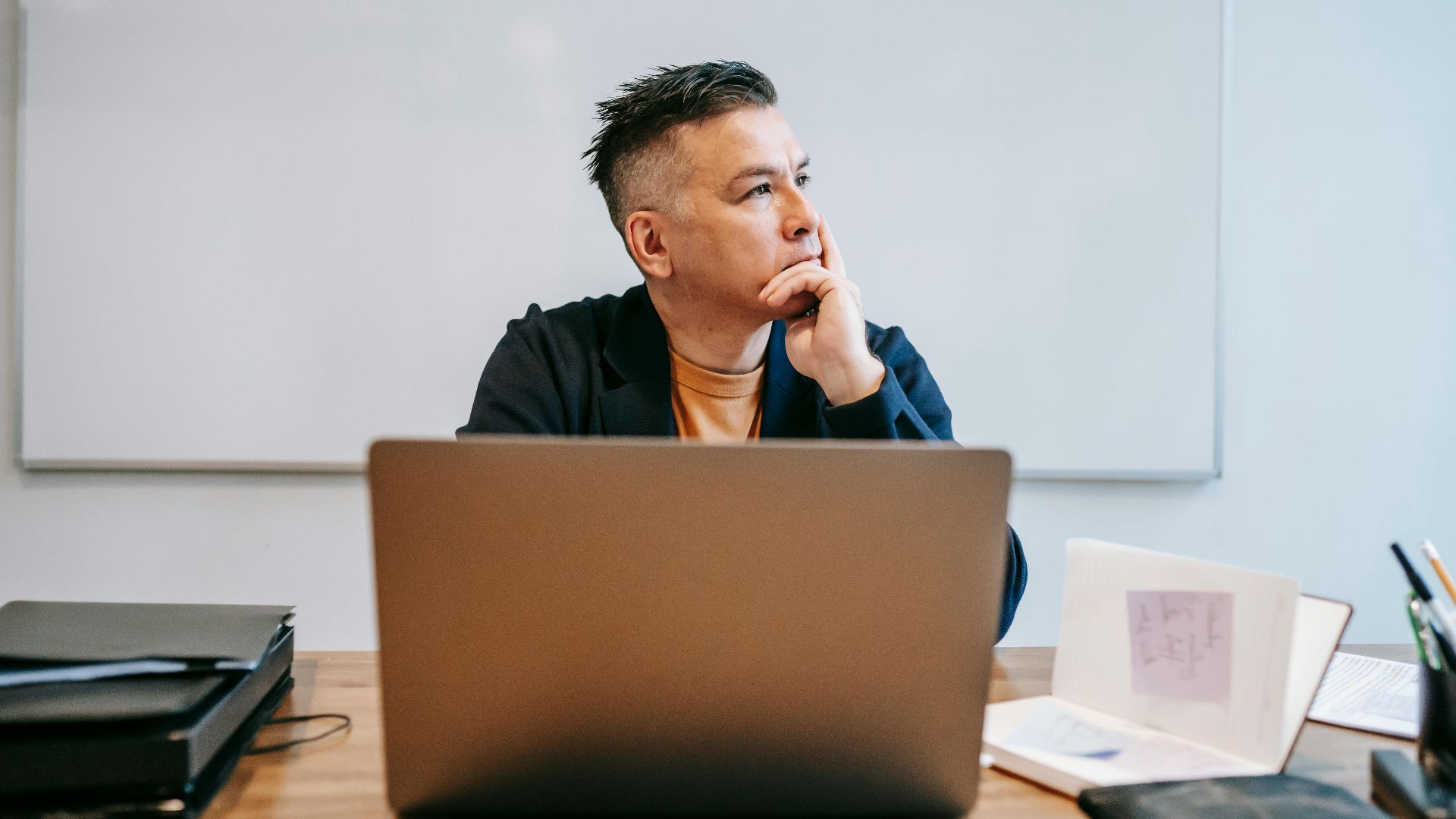 Focused businessman in home office, pondering work thoughts. Perfect for remote work and telecommuting concepts.