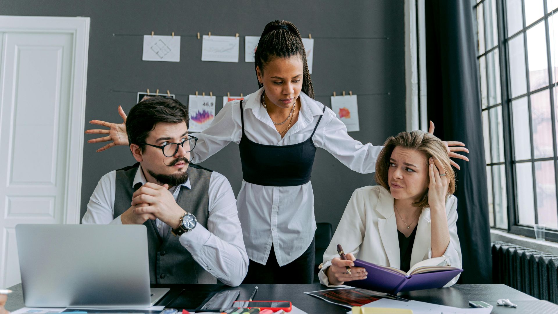 A diverse group of employees experiencing conflict at the office, depicting frustration and gesturing.