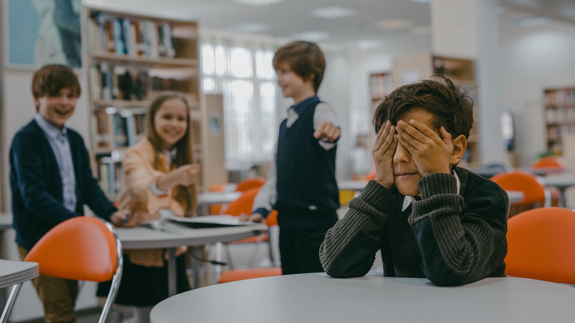 A group of children in a classroom, showing a bullying scenario.