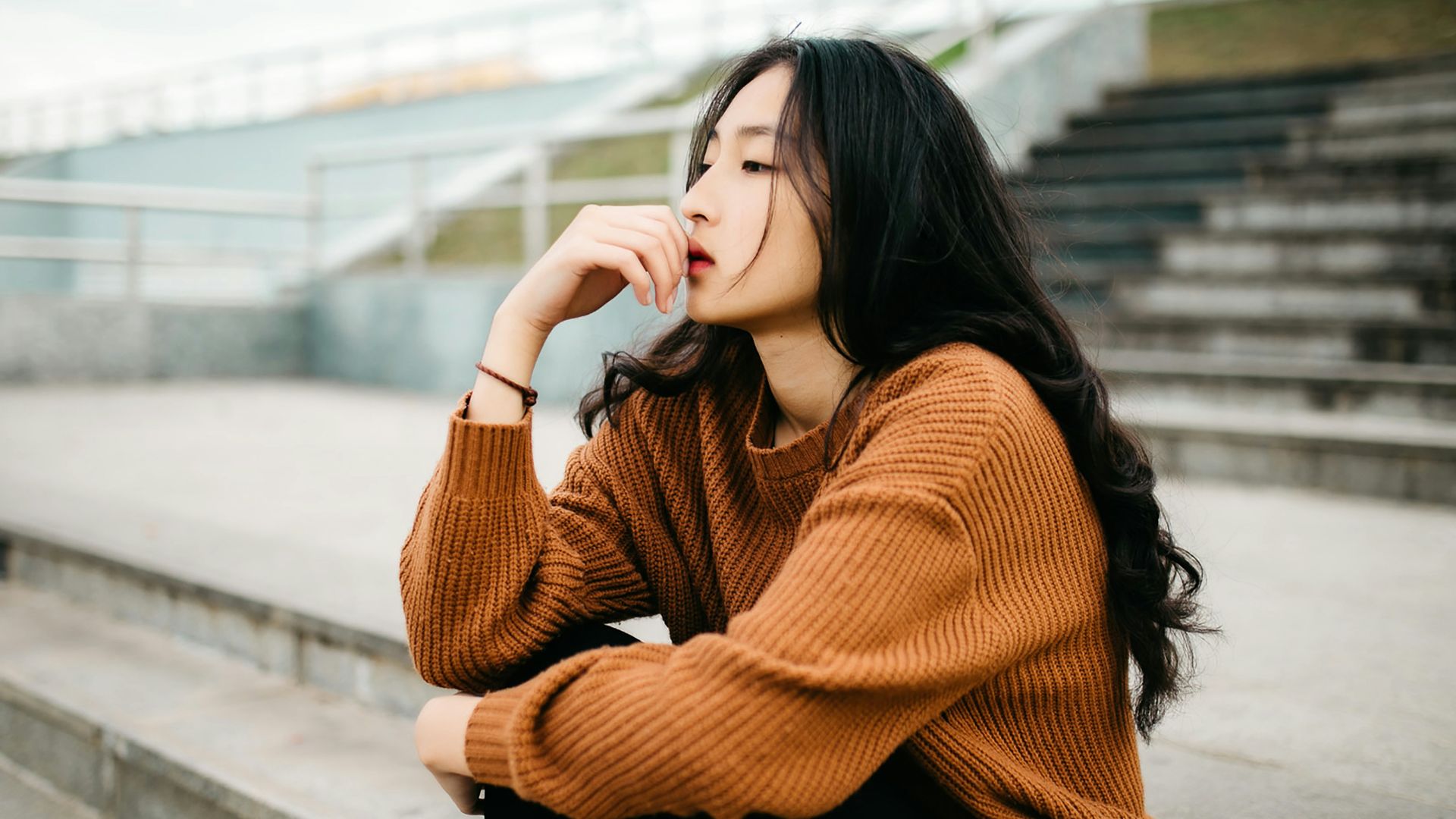 woman wearing brown sweater holding lips