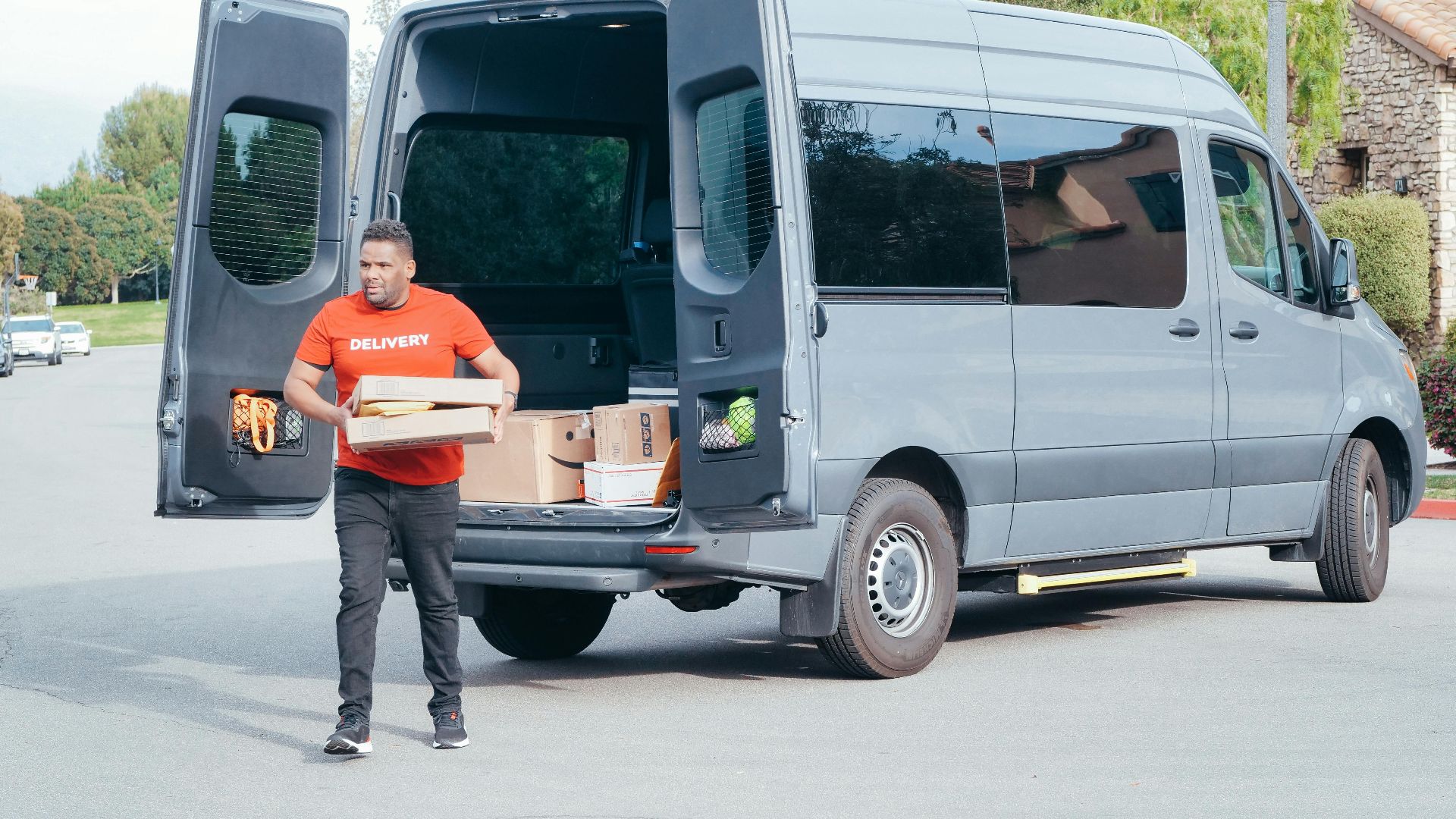 Courier in a delivery van distributing packages in a suburban setting.